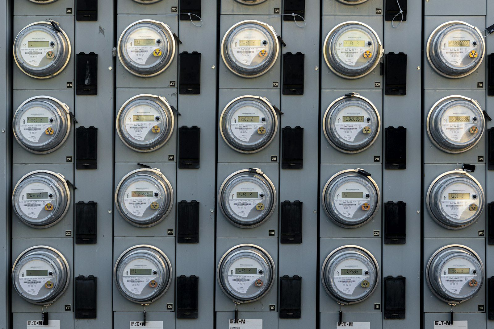 A bank of residential electricity meters, representing the quiet power users behind a summer bill