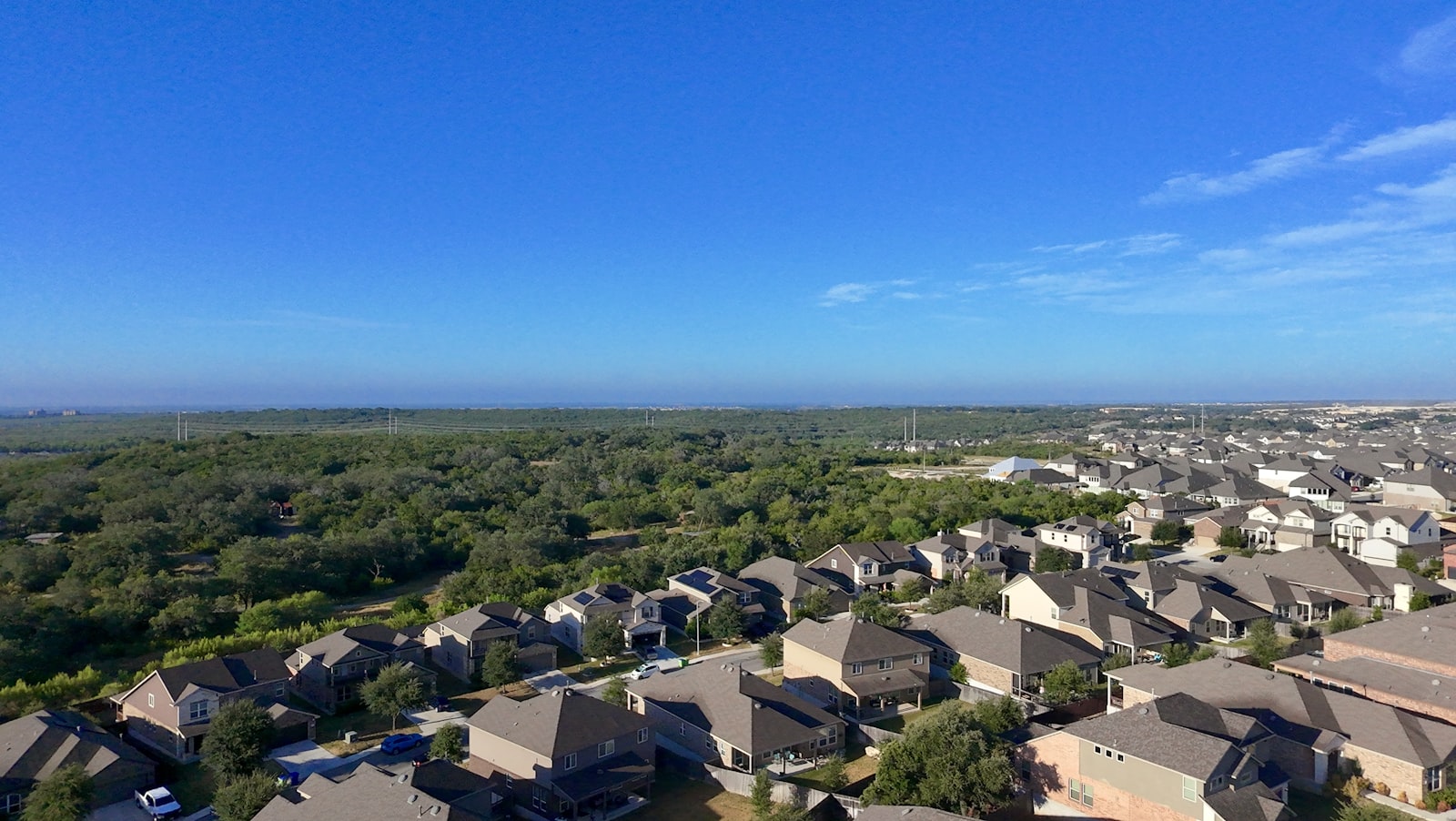 Aerial view of a North Texas suburban neighborhood — rows of brick homes with mature trees and clear Texas sky, representative of Celina, Prosper, and Collin County communities.