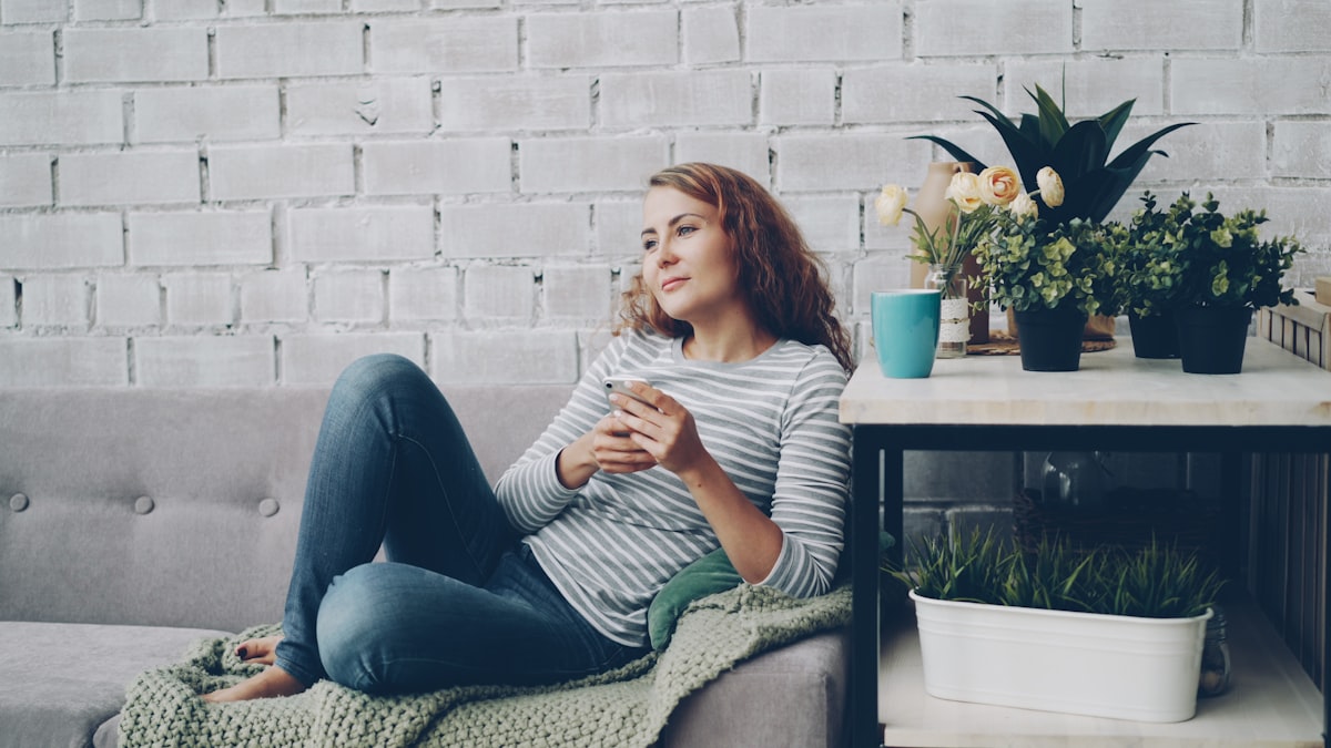 A homeowner relaxing, managing their home from their phone