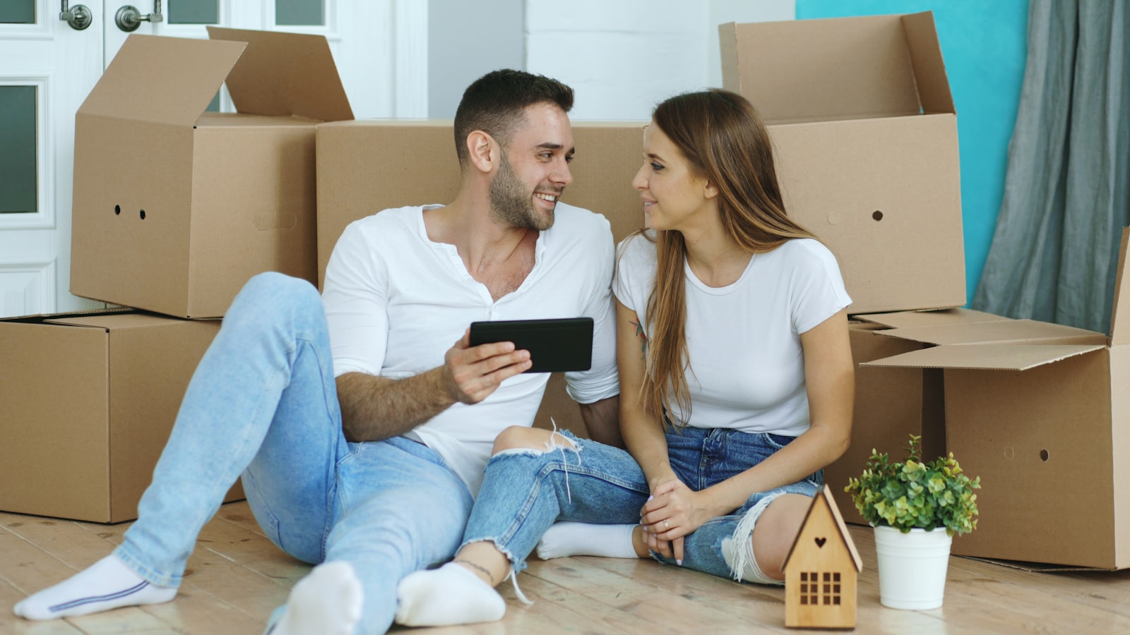 A couple in their new home surrounded by moving boxes, planning their setup